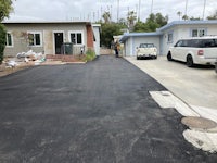 a black paved driveway in front of a house