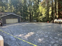 a concrete driveway in a wooded area