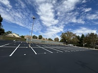 a parking lot with a blue sky and white clouds