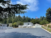 the driveway of a mobile home with a flag in the background