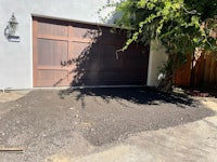 a driveway with a brown garage door