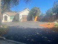 a driveway with a driveway and trees in the background