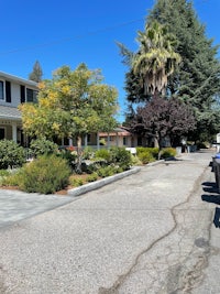a street with cars parked in front of a house