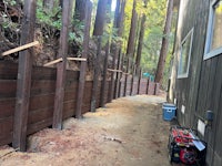 a wooden fence in the woods next to a house