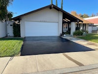 a black driveway with a garage in front of it