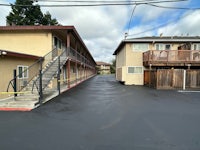 the parking lot of a motel with stairs leading up to a building