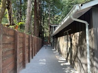 a wooden walkway leading to a house in the woods